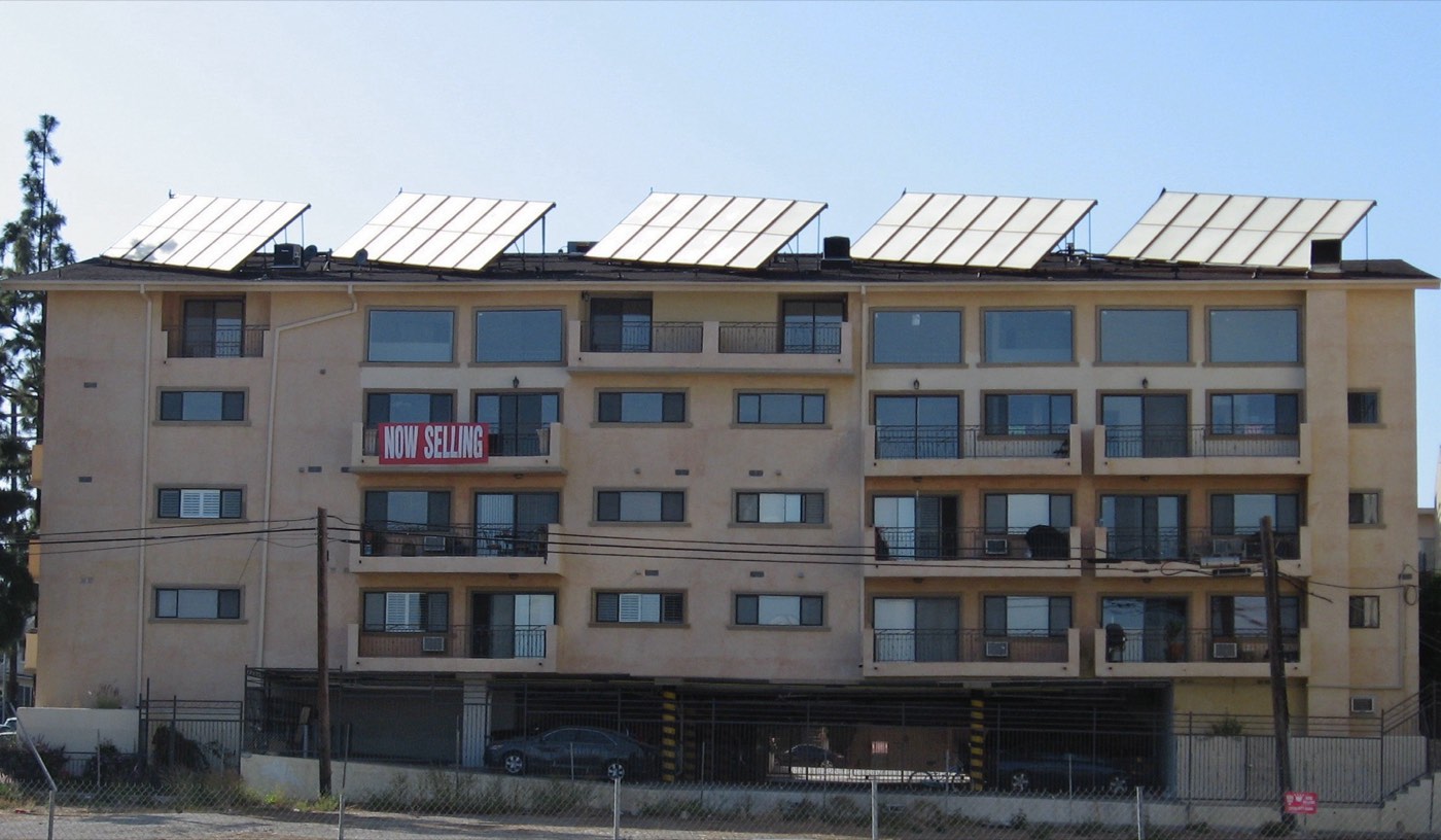 A residential apartment building with solar panels installed on the roof