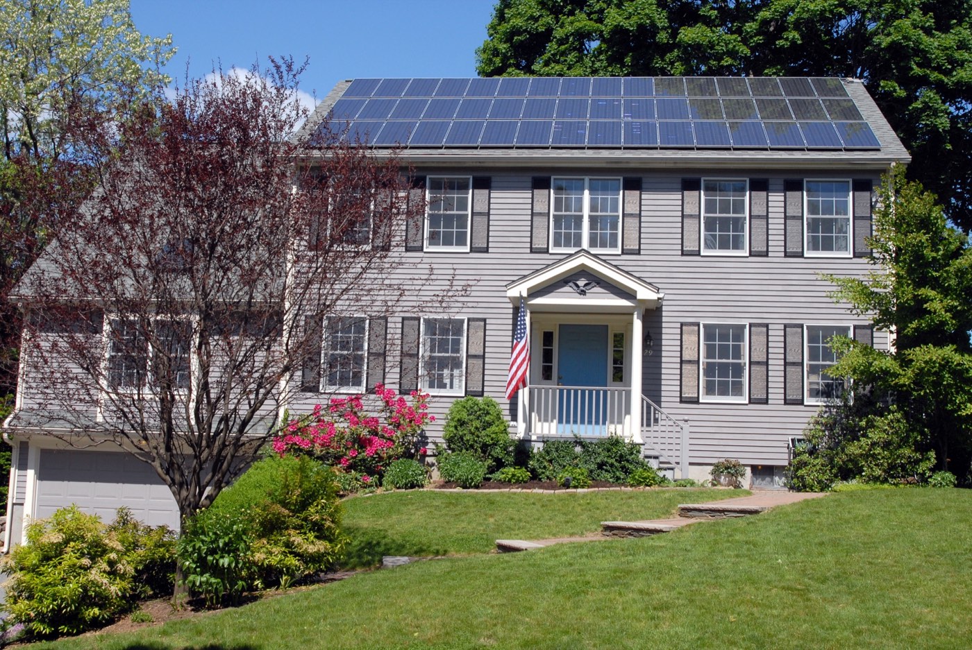 A house with solar panels installed across its roof on a sunny day