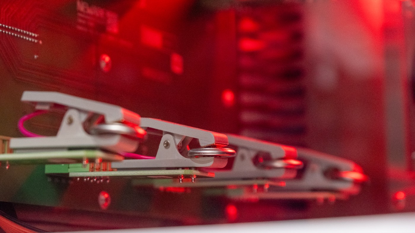 Lithium-ion coin cell batteries clamped into a laboratory testing fixture for controlled degradation testing