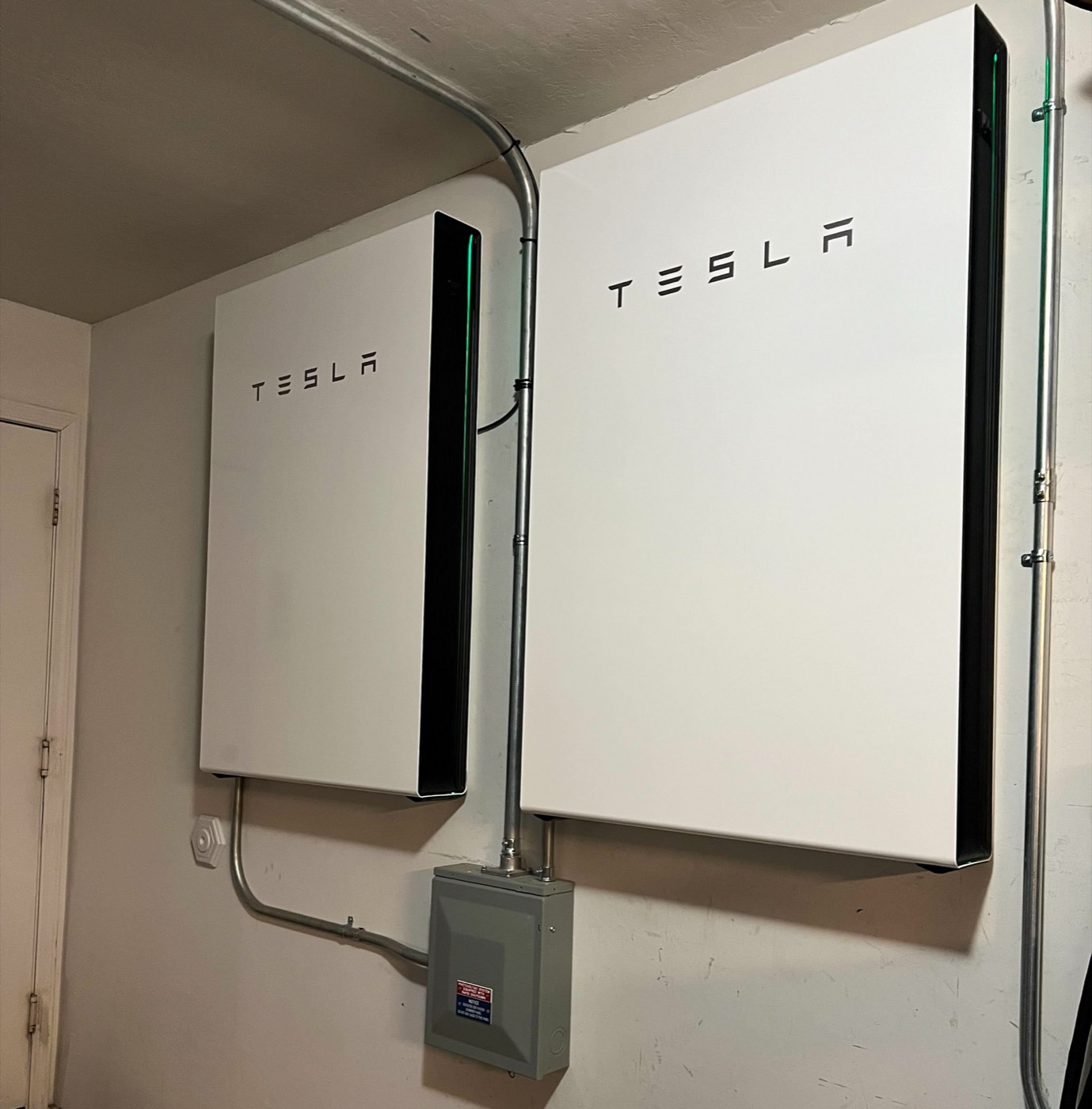 Two home battery units mounted on a garage wall