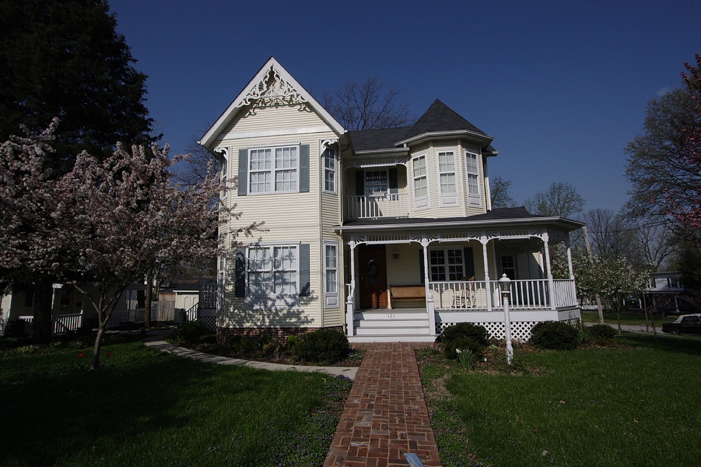 A restored Victorian house with a wraparound porch and decorative gable trim